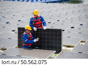 Photovoltaic engineers work on floating photovoltaics. Inspect and repair the solar panel equipment floating on the water. Стоковое фото, агентство Ingram Publishing / Фотобанк Лори
