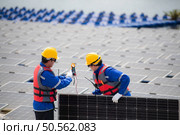 Photovoltaic engineers work on floating photovoltaics. Inspect and repair the solar panel equipment floating on the water. Стоковое фото, агентство Ingram Publishing / Фотобанк Лори