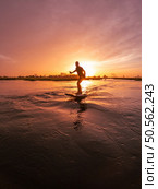 Hydrofoil rider gliding over the water with his board in one of the canals of the Ria de Aveiro in Portugal during sunset. Стоковое фото, агентство Ingram Publishing / Фотобанк Лори