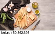 Fresh baked homemade grissini bread sticks in vintage metal grid box with olive oil and rosemary herbs over kitchen counter top. Стоковое фото, агентство Ingram Publishing / Фотобанк Лори