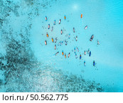 Aerial view of colorful boats, sea bay with transparent azure water on sunny day. Mnemba island, Zanzibar. Top view of sandbank in low tide, blue sea, sand, swimming people, yachts in summer. Ocean. Aerial view of colorful boats, sea bay with transparent water. Стоковое фото, агентство Ingram Publishing / Фотобанк Лори