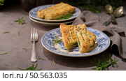 A rustic charm unfolds with a savory spinach pie on a vintage plate. Стоковое фото, агентство Ingram Publishing / Фотобанк Лори