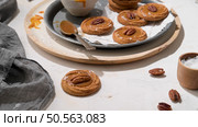 Caramel cookies with pecan nuts served on roud plates, in the kitchen after baking. Стоковое фото, агентство Ingram Publishing / Фотобанк Лори