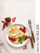 Crepes or thin pancakes with cheese cottage or curd and fresh red currant berries, top view. Стоковое фото, агентство Ingram Publishing / Фотобанк Лори