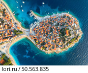 Aeriel view of old town on island at sunset. Summer in Primosten, Croatia, Adriatic Sea. Top drone view of houses, clear blue water, marina with boat and yachts, sandy beach. Travel. Aerial landscape. Стоковое фото, агентство Ingram Publishing / Фотобанк Лори