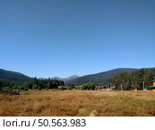 View of Hoverla Mountain in the Carpathians from the countryside grows green grass and a design for drying grass horizontal. Стоковое фото, агентство Ingram Publishing / Фотобанк Лори