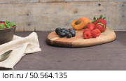 Yogurt with baked granola and berries in small bowl strawberries blueberries. Granola baked with nuts and honey for little sweetness. Slide from right. Стоковое фото, агентство Ingram Publishing / Фотобанк Лори