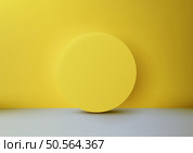 Vibrant yellow circle casts a soft shadow on a gray floor against a bold yellow wall. Perfect for minimalist product displays, mockups, and modern design showcases. Стоковая иллюстрация, агентство Ingram Publishing / Фотобанк Лори
