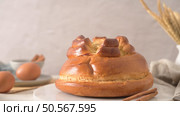 A golden-brown challah bread with a decorative top, surrounded by eggs and cinnamon sticks. Стоковое фото, агентство Ingram Publishing / Фотобанк Лори