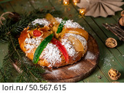 A festive King Cake adorned with colorful candied fruits, dusted with powdered sugar, and ready to be shared. Стоковое фото, агентство Ingram Publishing / Фотобанк Лори