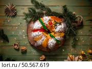 A festive King Cake adorned with colorful candied fruits, dusted with powdered sugar, and ready to be shared. Стоковое фото, агентство Ingram Publishing / Фотобанк Лори