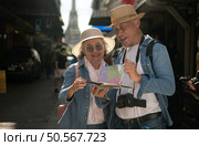 Elderly couples and their activities on the road at the end of the alley where there is a pagoda of Wat Arun, Thailand. Стоковое фото, агентство Ingram Publishing / Фотобанк Лори
