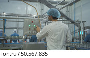 The production control supervisor inspects and controls the operation of machines in the manufacturing line of a canned fish industry. Стоковое фото, агентство Ingram Publishing / Фотобанк Лори