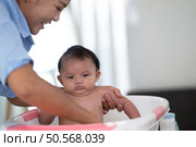 A mother bathes her little daughter in a small children’s tub. Стоковое фото, агентство Ingram Publishing / Фотобанк Лори