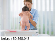 A mother bathes her little daughter in a small children’s tub. Стоковое фото, агентство Ingram Publishing / Фотобанк Лори