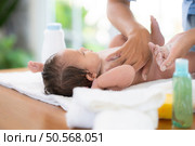 Following a bath, a mother applies powder and dresses her tiny daughter. Стоковое фото, агентство Ingram Publishing / Фотобанк Лори