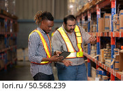 A group of warehouse employees, Inspecting products on warehouse shelves before they are sent to retailer. Стоковое фото, агентство Ingram Publishing / Фотобанк Лори