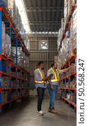 A group of warehouse employees, Inspecting products on warehouse shelves before they are sent to retailer. Стоковое фото, агентство Ingram Publishing / Фотобанк Лори