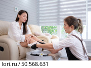 After cleansing the customer’s legs, The manicurist will wrap plastic around them after apply skin care cream. Стоковое фото, агентство Ingram Publishing / Фотобанк Лори