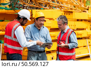 Foreman and worker on construction crane inspection is made to transport the crane from storage to be assembled on the building construction site. Стоковое фото, агентство Ingram Publishing / Фотобанк Лори