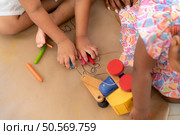 On a holiday, A woman and her two little daughters sit on the floor and drawing together in the living room. Стоковое фото, агентство Ingram Publishing / Фотобанк Лори