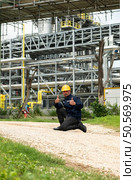 Petroleum engineer is on a mission to inspect oil distillation at a huge oil refinery. Стоковое фото, агентство Ingram Publishing / Фотобанк Лори