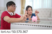 Three siblings save money by putting it in a piggy bank, This is an activity that parents teach their children about saving money. Стоковое фото, агентство Ingram Publishing / Фотобанк Лори