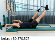 A young man and a young woman are doing pilates exercises on a pilates reformer. Стоковое фото, агентство Ingram Publishing / Фотобанк Лори