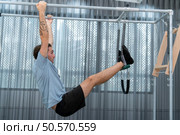 A young man doing pilates exercises on a pilates cadillac. Стоковое фото, агентство Ingram Publishing / Фотобанк Лори