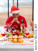 Grandfather leads a prayer and blessing before the family meal during the Christmas celebration at home. Стоковое фото, агентство Ingram Publishing / Фотобанк Лори
