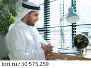 Portrait of young Arabic businessman working on laptop at home. Стоковое фото, агентство Ingram Publishing / Фотобанк Лори