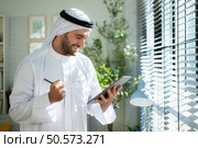 Portrait of young Arabic businessman working on laptop at home. Стоковое фото, агентство Ingram Publishing / Фотобанк Лори