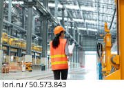 Portrait of a young female technician using a blueprint working and standing in a skytrain repair station. Стоковое фото, агентство Ingram Publishing / Фотобанк Лори