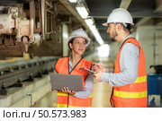 Male and female engineers work together in an electric repair station. Inspecting the undercarriage of electric train that are being repaired at the garage. Стоковое фото, агентство Ingram Publishing / Фотобанк Лори