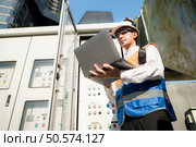 Before proceeding with the testing, Electrical engineer inspects the installed control panel. Стоковое фото, агентство Ingram Publishing / Фотобанк Лори