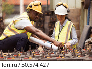 Railway technicians worker in safety vest and helmet inspect the battery in the train workshop. Стоковое фото, агентство Ingram Publishing / Фотобанк Лори