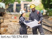 Railway technicians and engineers, Working on the train tracks at train station. Стоковое фото, агентство Ingram Publishing / Фотобанк Лори
