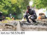 Portrait of a railway engineer on the tracks of a train in station platform. Стоковое фото, агентство Ingram Publishing / Фотобанк Лори