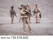 Soldiers in camouflage military uniforms carrying weapons, Reconnaissance missions in rugged mountains, Assault infantry battle training. Стоковое фото, агентство Ingram Publishing / Фотобанк Лори