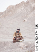 A Taliban soldier with a machine gun, In the desert mountain landscape. Стоковое фото, агентство Ingram Publishing / Фотобанк Лори