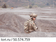 A Taliban soldier stands with a machine gun, Surrender to the allied soldiers, In the desert mountain terrain battlefield. Стоковое фото, агентство Ingram Publishing / Фотобанк Лори