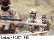 Soldiers in camouflage military uniforms carrying weapons, Reconnaissance missions in the tropical forest area, Assault infantry battle training. Стоковое фото, агентство Ingram Publishing / Фотобанк Лори