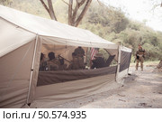 Group of soldiers in camouflage uniforms hold weapons in a field tent, Plan and prepare for combat training. Стоковое фото, агентство Ingram Publishing / Фотобанк Лори