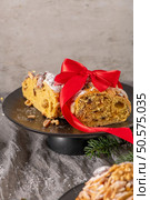 A slice of Bolo Rainha, a Portuguese Christmas cake, is presented on a stand, tied with a bright red ribbon, making it a perfect holiday gift. Стоковое фото, агентство Ingram Publishing / Фотобанк Лори
