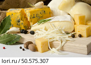 Various types of cheese with spice on the wooden board. Стоковое фото, агентство Ingram Publishing / Фотобанк Лори