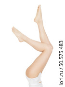 Nothing but legs. Shot of beautiful legs of a sexy young female model with perfect skin wearing top and shorts at the studio on white background copyspace on the side. Стоковое фото, агентство Ingram Publishing / Фотобанк Лори