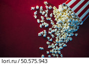 Spilled popcorn on a red background, cinema, movies and entertainment concept. Стоковое фото, агентство Ingram Publishing / Фотобанк Лори