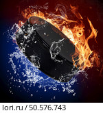 Hockey puck in fire flames and splashing water. Стоковое фото, агентство Ingram Publishing / Фотобанк Лори