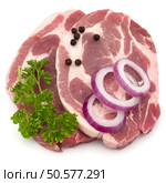 Raw pork neck chop meat with parsley herb leaves, peppercorn spices and onion slices garnish isolated on white background cutout. Стоковое фото, агентство Ingram Publishing / Фотобанк Лори