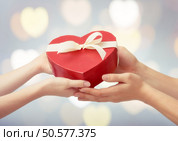 red gift box in shape of heart in hands. the concept of love and Valentine’s day. Стоковое фото, агентство Ingram Publishing / Фотобанк Лори